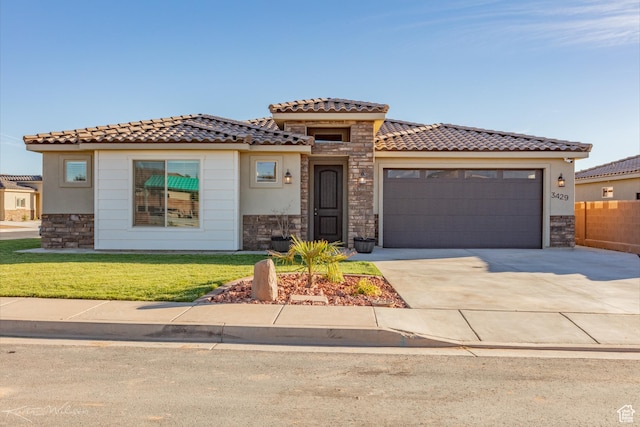 3429 W 175 N, Hurricane, UT 84737 - mediterranean / spanish-style house featuring stone siding, concrete driveway, a garage, a front lawn, and a tile roof