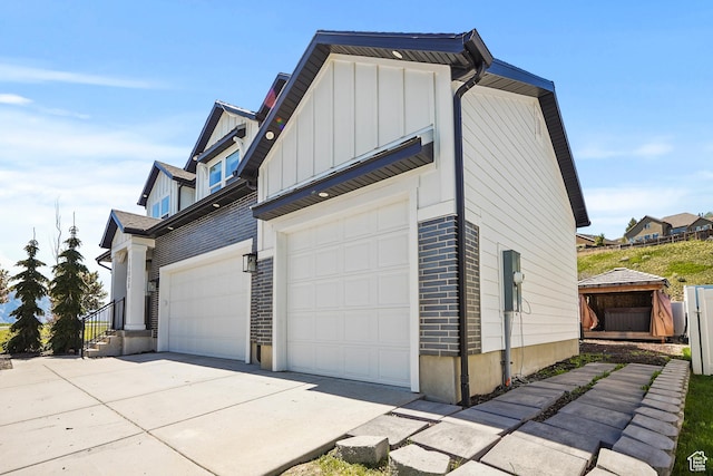 15008 S Springtime Rd, Draper Ut Cnty, UT 84020 - view of side of home featuring board and batten siding, concrete driveway, a garage, and brick siding