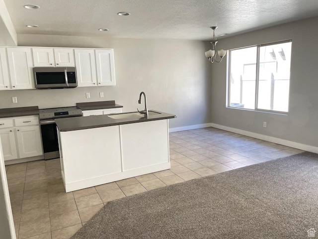 2126 W Fernside St, West Haven, UT 84401 - kitchen with appliances with stainless steel finishes, dark countertops, white cabinets, a textured ceiling, and light tile patterned floors