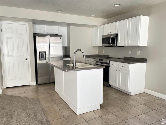 2126 W Fernside St, West Haven, UT 84401 - kitchen featuring stainless steel appliances, dark countertops, light tile patterned floors, a textured ceiling, and white cabinets