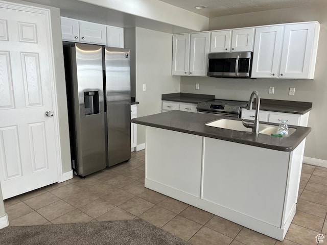 2126 W Fernside St, West Haven, UT 84401 - kitchen with appliances with stainless steel finishes, dark countertops, white cabinetry, and tile patterned flooring