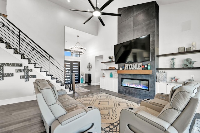 2673 S 4950 W, Taylor, UT 84401 - living room with wood finished floors, a ceiling fan, a high ceiling, stairway, and a fireplace