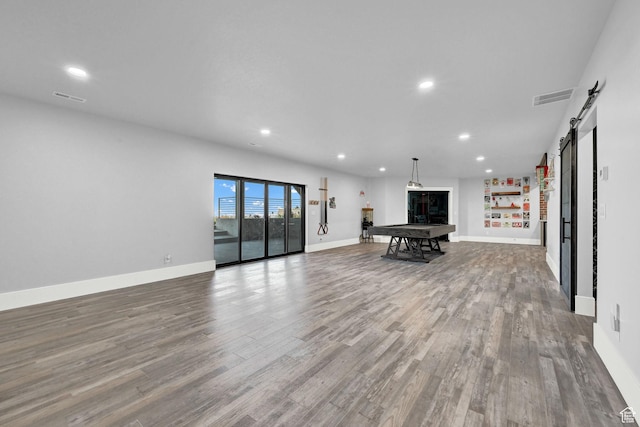 2673 S 4950 W, Taylor, UT 84401 - unfurnished living room with a barn door, wood finished floors, and recessed lighting