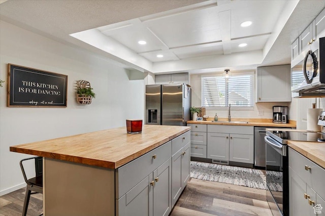 5659 Woodshire Ct, South Ogden, UT 84403 - kitchen featuring wooden counters, stainless steel appliances, gray cabinets, light wood finished floors, and a kitchen island
