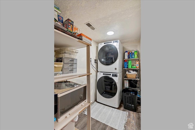 5659 Woodshire Ct, South Ogden, UT 84403 - laundry area with stacked washing machine and dryer, wood finished floors, and a textured ceiling