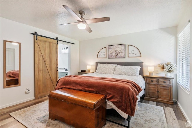 5659 Woodshire Ct, South Ogden, UT 84403 - bedroom featuring a barn door, wood finished floors, and multiple windows