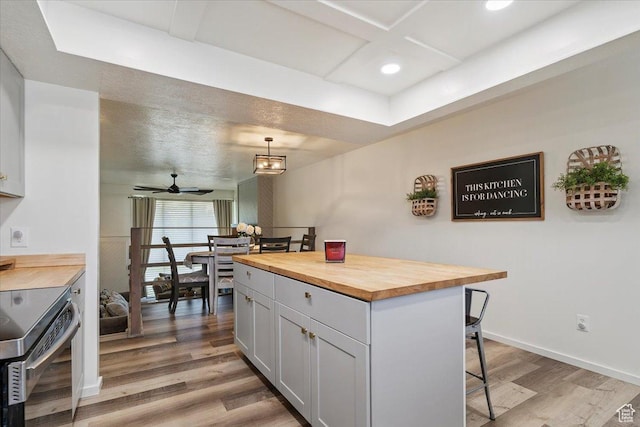 5659 Woodshire Ct, South Ogden, UT 84403 - kitchen with butcher block counters, stainless steel electric range oven, a breakfast bar area, light wood finished floors, and recessed lighting