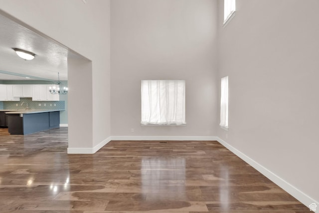 797 E 10 S, American Fork, UT 84003 - unfurnished living room with a chandelier, healthy amount of natural light, wood finished floors, and a high ceiling
