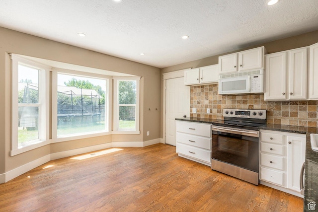 1104 E 220 N, Heber City, UT 84032 - kitchen featuring white microwave, stainless steel range with electric stovetop, dark countertops, light wood finished floors, and backsplash