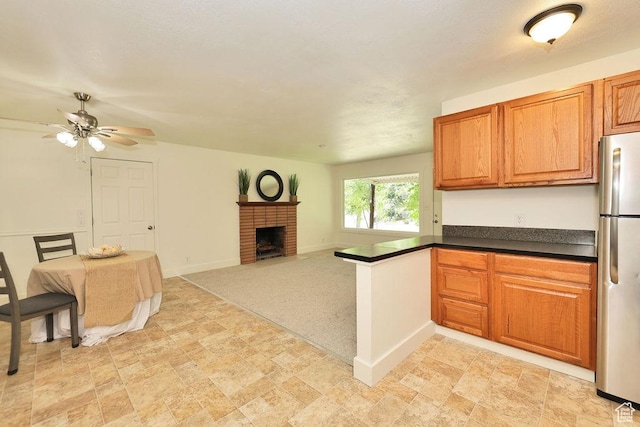 3165 S Jackson Ave, Ogden, UT 84403 - kitchen featuring freestanding refrigerator, open floor plan, a peninsula, ceiling fan, and a brick fireplace
