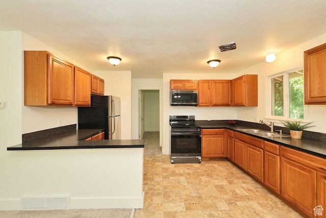 3165 S Jackson Ave, Ogden, UT 84403 - kitchen featuring appliances with stainless steel finishes, dark countertops, brown cabinets, and a peninsula