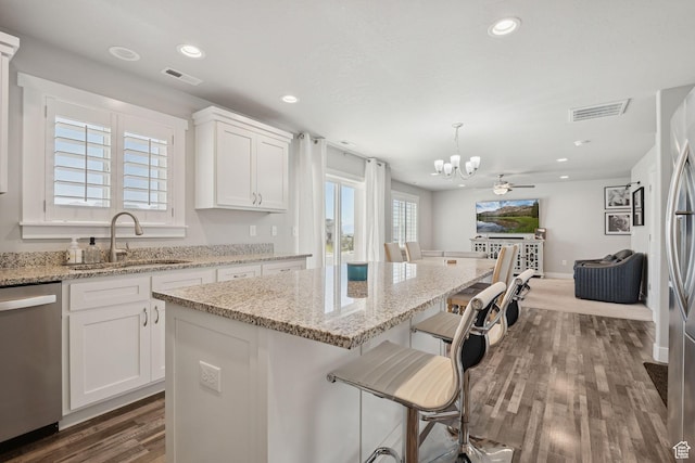 9634 N Red Bridge Rd, Eagle Mountain, UT 84005 - kitchen featuring stainless steel dishwasher, a chandelier, dark wood-style flooring, a kitchen island, and white cabinetry