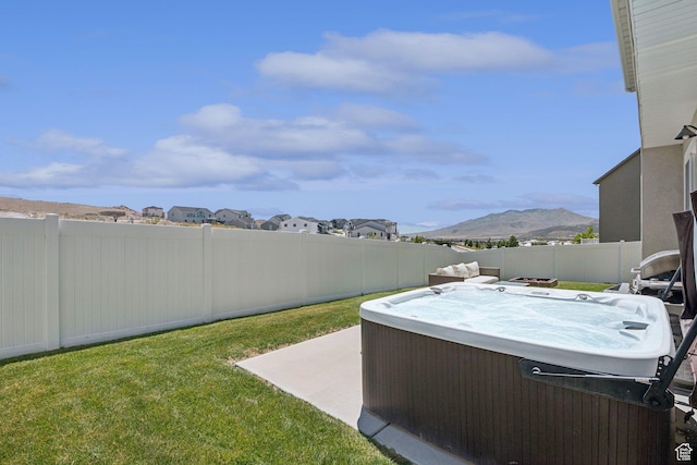 9634 N Red Bridge Rd, Eagle Mountain, UT 84005 - fenced backyard with a hot tub, a mountain view, and a patio area