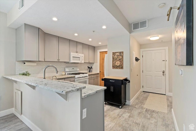 6641 N 2200 W Unit A107, Park City, UT 84098 - kitchen with white appliances, light wood-style floors, light stone countertops, decorative backsplash, and recessed lighting