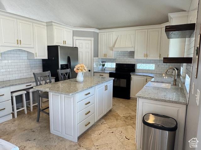421 S 755 E, Layton, UT 84041 - kitchen with black range with electric stovetop, premium range hood, stainless steel refrigerator with ice dispenser, decorative backsplash, and a kitchen island