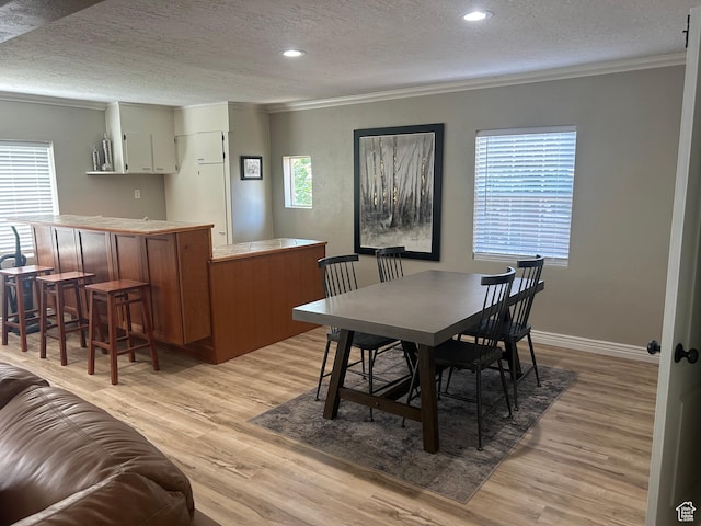 2537 S Taylor Ave E, Ogden, UT 84401 - dining room featuring crown molding, light wood-type flooring, a textured ceiling, and recessed lighting