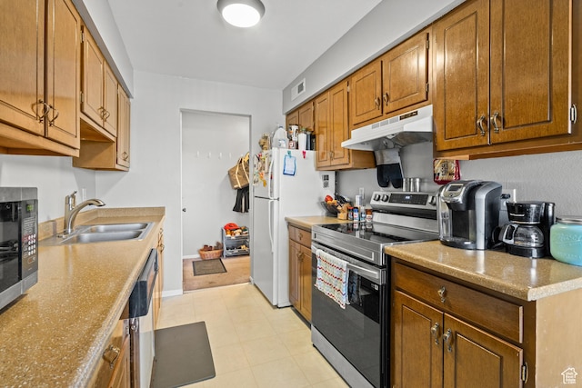 290 N 500 W Unit 210, Bountiful, UT 84010 - kitchen featuring under cabinet range hood, appliances with stainless steel finishes, brown cabinetry, and light countertops