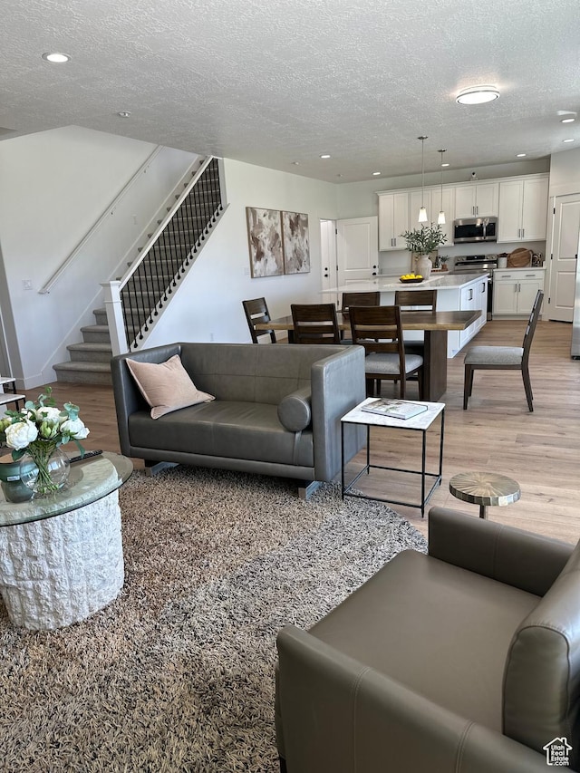 325 S 2800 E Unit 203, Spanish Fork, UT 84660 - living area featuring stairs, light wood finished floors, a textured ceiling, and recessed lighting