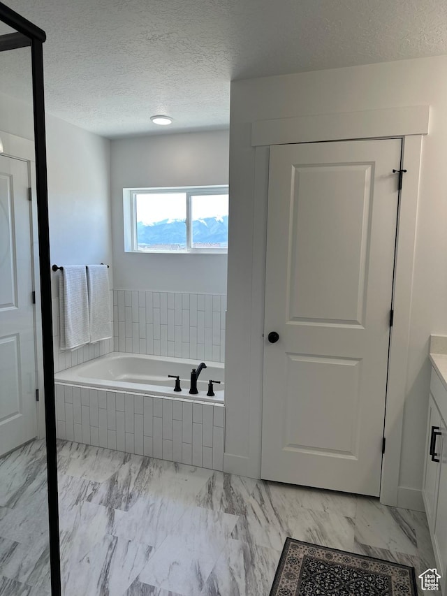 325 S 2800 E Unit 203, Spanish Fork, UT 84660 - full bath featuring vanity, a bath, marble look tile flooring, and a textured ceiling