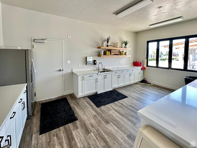 214 W Whitewater Dr, Vineyard, UT 84059 - kitchen featuring stainless steel refrigerator with ice dispenser, wood finished floors, white cabinetry, light countertops, and a textured ceiling
