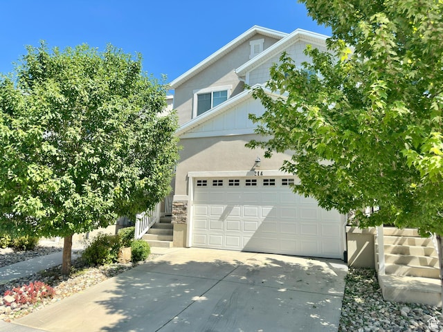 214 W Whitewater Dr, Vineyard, UT 84059 - view of front of house with driveway, stucco siding, an attached garage, board and batten siding, and stone siding