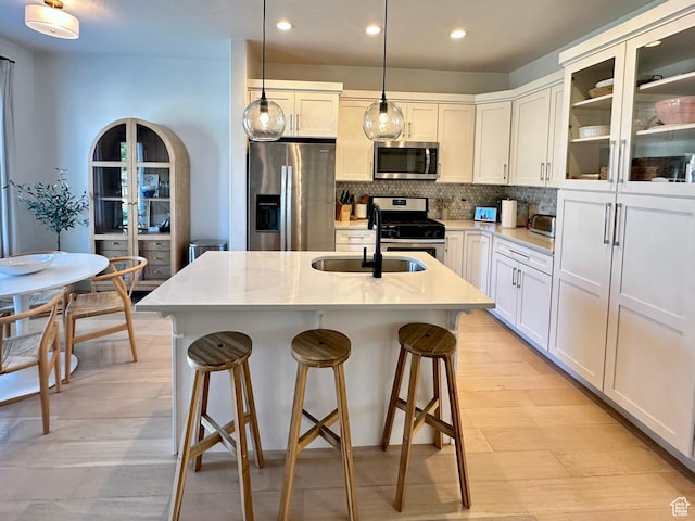 214 W Whitewater Dr, Vineyard, UT 84059 - kitchen featuring appliances with stainless steel finishes, recessed lighting, backsplash, light countertops, and a breakfast bar
