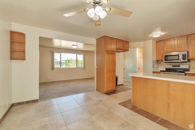 1241 W 4505 S, Taylorsville, UT 84123 - kitchen featuring appliances with stainless steel finishes, light countertops, decorative backsplash, light colored carpet, and a ceiling fan