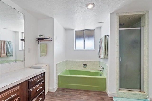 1252 N 100 E, American Fork, UT 84003 - bathroom featuring a textured ceiling, wood finished floors, vanity, a bath, and a stall shower
