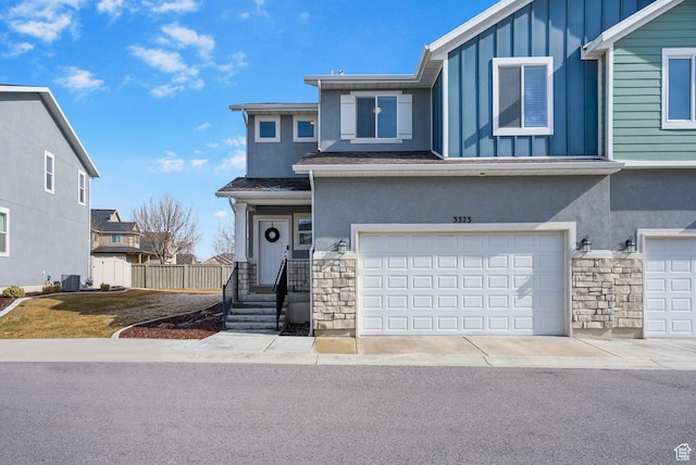 3323 E Gibraltar Ave, Eagle Mountain, UT 84005 - view of front of home with stone siding, stucco siding, an attached garage, and board and batten siding