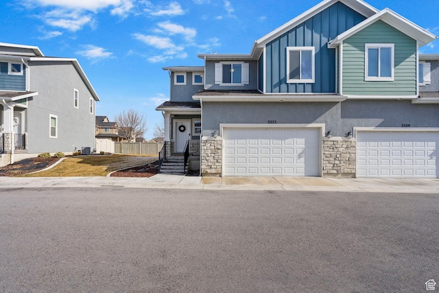 3323 E Gibraltar Ave, Eagle Mountain, UT 84005 - view of front of house featuring board and batten siding, stone siding, an attached garage, and stucco siding