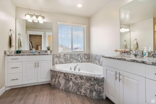 3323 E Gibraltar Ave, Eagle Mountain, UT 84005 - bathroom with two vanities, a garden tub, and wood finished floors