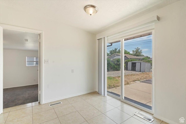 330 W 750 N, Clearfield, UT 84015 - spare room with plenty of natural light, light tile patterned floors, a textured ceiling, and light colored carpet