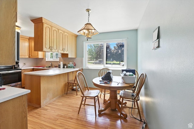 735 E 100 S, Hyrum, UT 84319 - kitchen with electric stove, light wood-style flooring, a chandelier, light countertops, and a peninsula