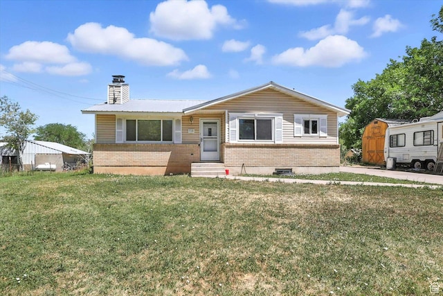 735 E 100 S, Hyrum, UT 84319 - view of front of home with entry steps, brick siding, a chimney, and a front yard