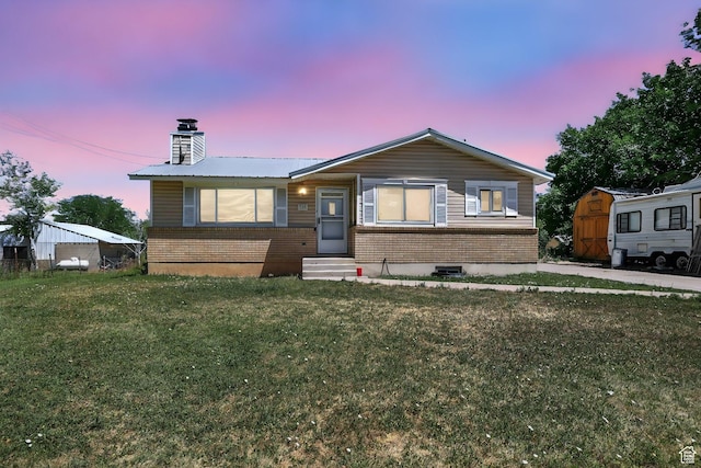 735 E 100 S, Hyrum, UT 84319 - view of front facade with entry steps, brick siding, a chimney, and a lawn