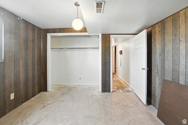 735 E 100 S, Hyrum, UT 84319 - unfurnished bedroom featuring unfinished concrete flooring, wood walls, and a closet