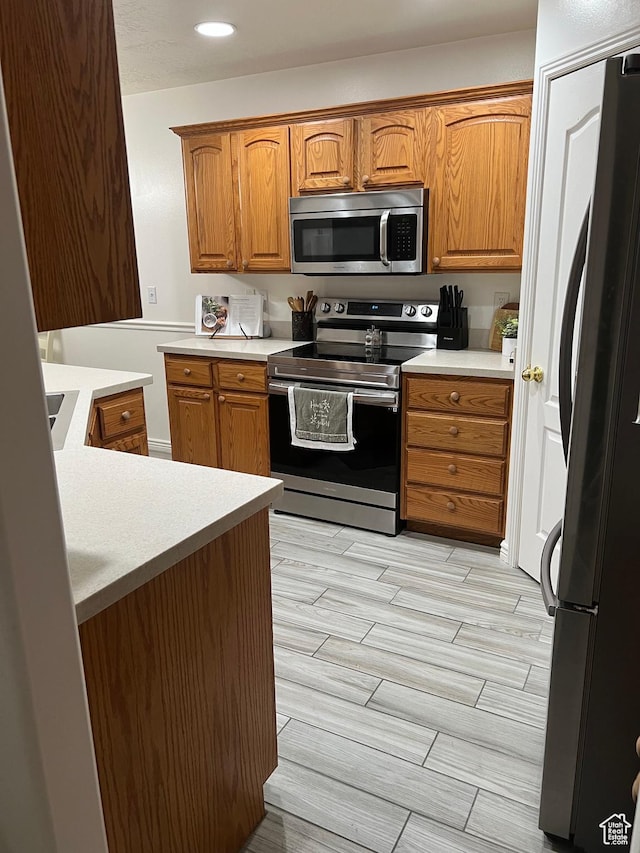 798 W Norway Maple Ct, Payson, UT 84651 - kitchen with stainless steel appliances, wood finish floors, brown cabinetry, light countertops, and recessed lighting