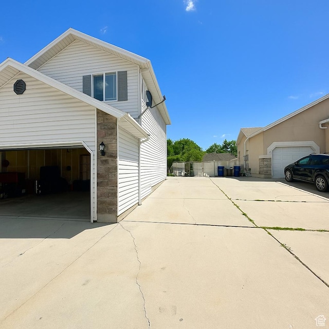 2879 S Fetzer Dr W, Magna, UT 84044 - view of home's exterior with a garage, concrete driveway, and stone siding