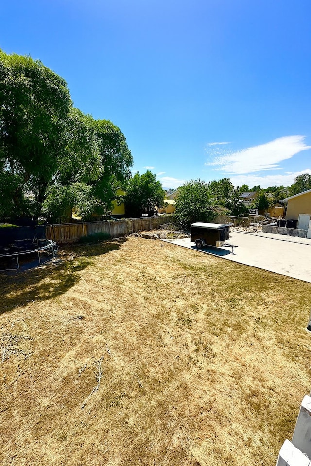 2879 S Fetzer Dr W, Magna, UT 84044 - fenced backyard with a trampoline and a patio area