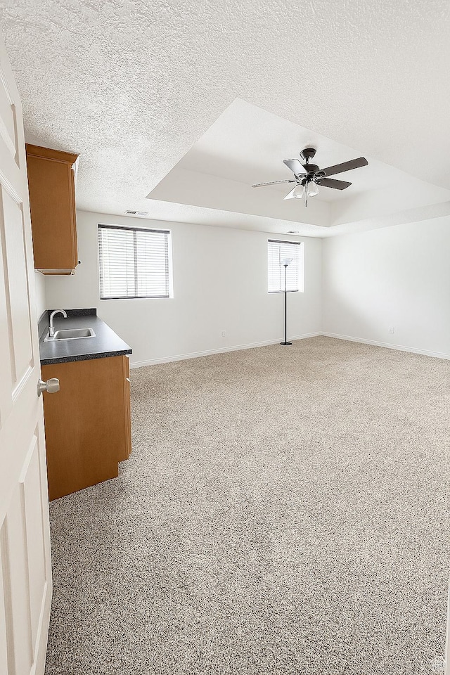 2879 S Fetzer Dr W, Magna, UT 84044 - unfurnished living room with a textured ceiling, a ceiling fan, healthy amount of natural light, and carpet