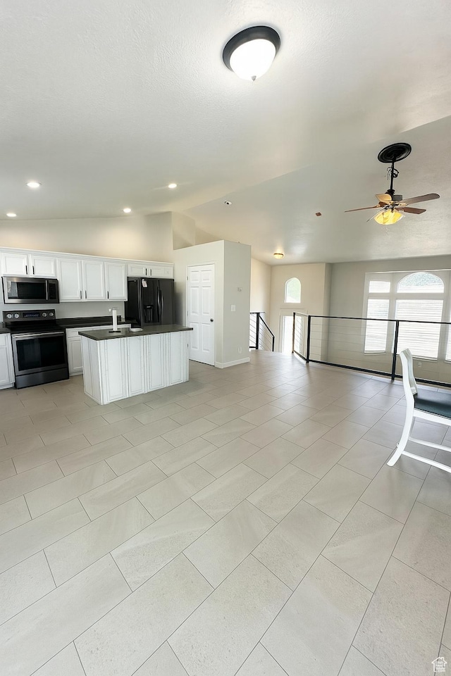 2879 S Fetzer Dr W, Magna, UT 84044 - kitchen with stainless steel appliances, open floor plan, dark countertops, white cabinets, and a ceiling fan
