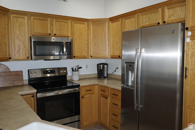 14072 S Julien Cv, Bluffdale, UT 84065 - kitchen featuring appliances with stainless steel finishes, light countertops, and brown cabinetry