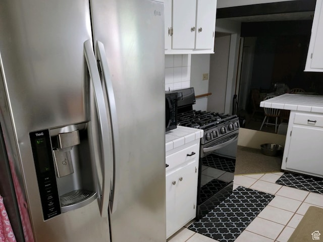 30 N Main St, Aurora, UT 84620 - kitchen featuring appliances with stainless steel finishes, tile counters, white cabinets, and light tile patterned floors