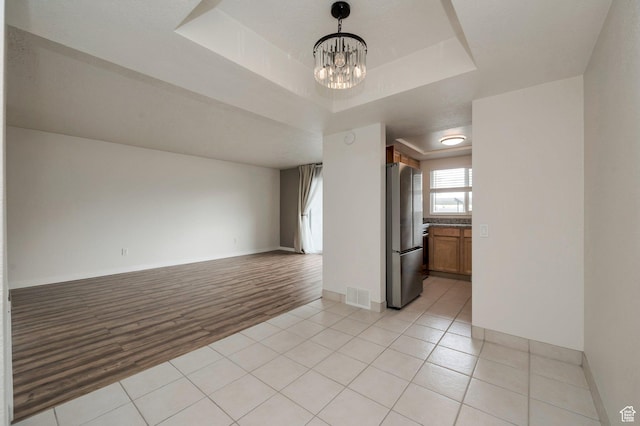 588 E Vine St S Unit 2C, Murray, UT 84107 - empty room featuring a chandelier, a tray ceiling, and light tile patterned floors