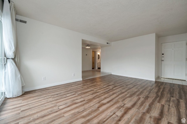 588 E Vine St S Unit 2C, Murray, UT 84107 - spare room with light wood-style floors and a textured ceiling