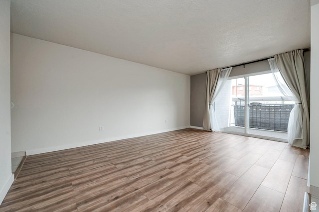 588 E Vine St S Unit 2C, Murray, UT 84107 - spare room featuring wood finished floors and a textured ceiling