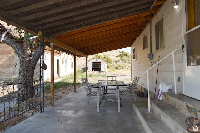 215 N Center St, Castle Dale, UT 84513 - view of patio featuring a storage unit and outdoor dining space