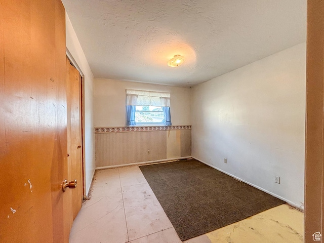 215 N Center St, Castle Dale, UT 84513 - empty room with wainscoting and a textured ceiling