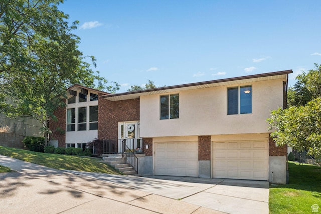784 E 2150 S, Bountiful, UT 84010 - raised ranch featuring driveway, brick siding, a garage, stucco siding, and a front lawn