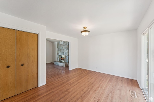 784 E 2150 S, Bountiful, UT 84010 - unfurnished living room with light wood finished floors, plenty of natural light, and a stone fireplace